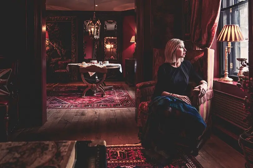 The founder of Red Camellia working through an itinerary at a table by a window